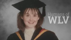 Debra Cureton in her graduation robes in front of a grey backdrop with white text reading Humans of WLV