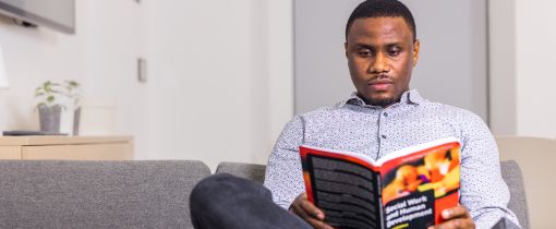 A student sitting and reading a book